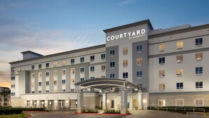 A Courtyard by Marriott hotel with a covered entrance, multiple floors, and a parking area. - Courtyard by Marriott Houston Kemah (Kemah)