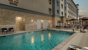 A swimming pool area with lounge chairs and a covered seating area. - Courtyard by Marriott Houston Kemah (Kemah)