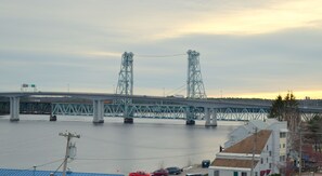 A large steel bridge spanning a river with a cityscape in the background.