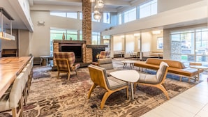 A spacious lobby with a fireplace, comfortable seating, and large windows. - Residence Inn by Marriott Duluth (Duluth)