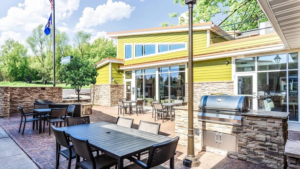 An outdoor patio with a grill, tables, and chairs. - Residence Inn by Marriott Duluth (Duluth)