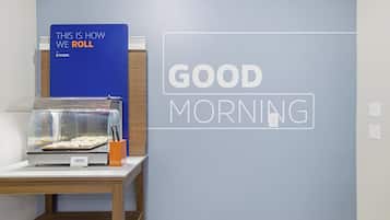 A breakfast display with a sign that reads "THIS IS HOW WE ROLL" and a wall sign saying "GOOD MORNING".
