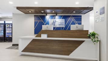 A reception desk with a blue and white color scheme, a wooden accent, and a Holiday Inn Express sign.