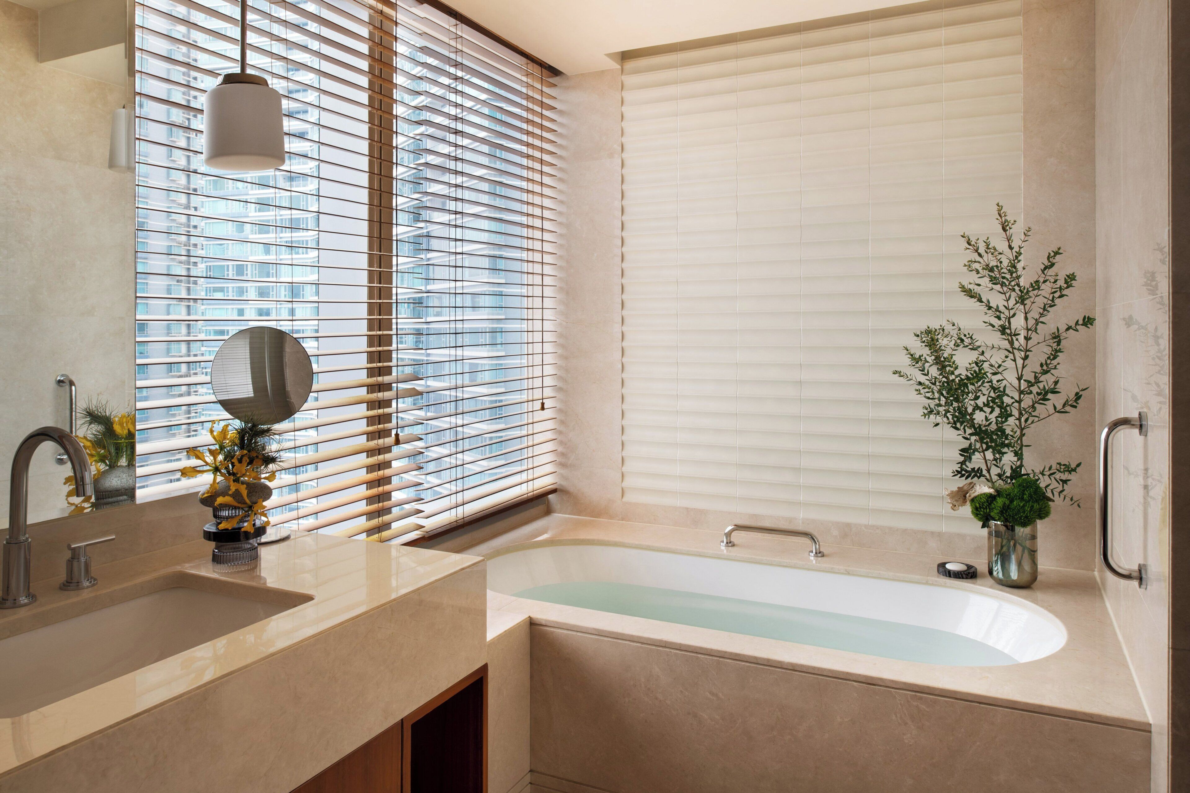 A modern bathroom with a bathtub, a sink, and a mirror.