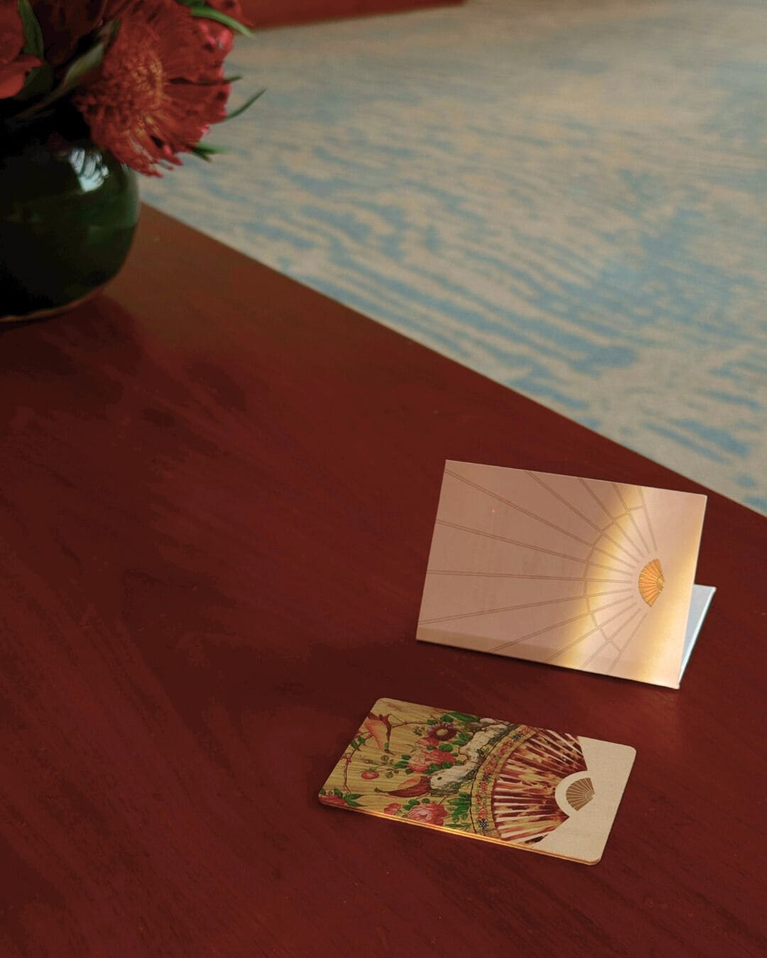 A wooden table with a card and a decorative item on it.