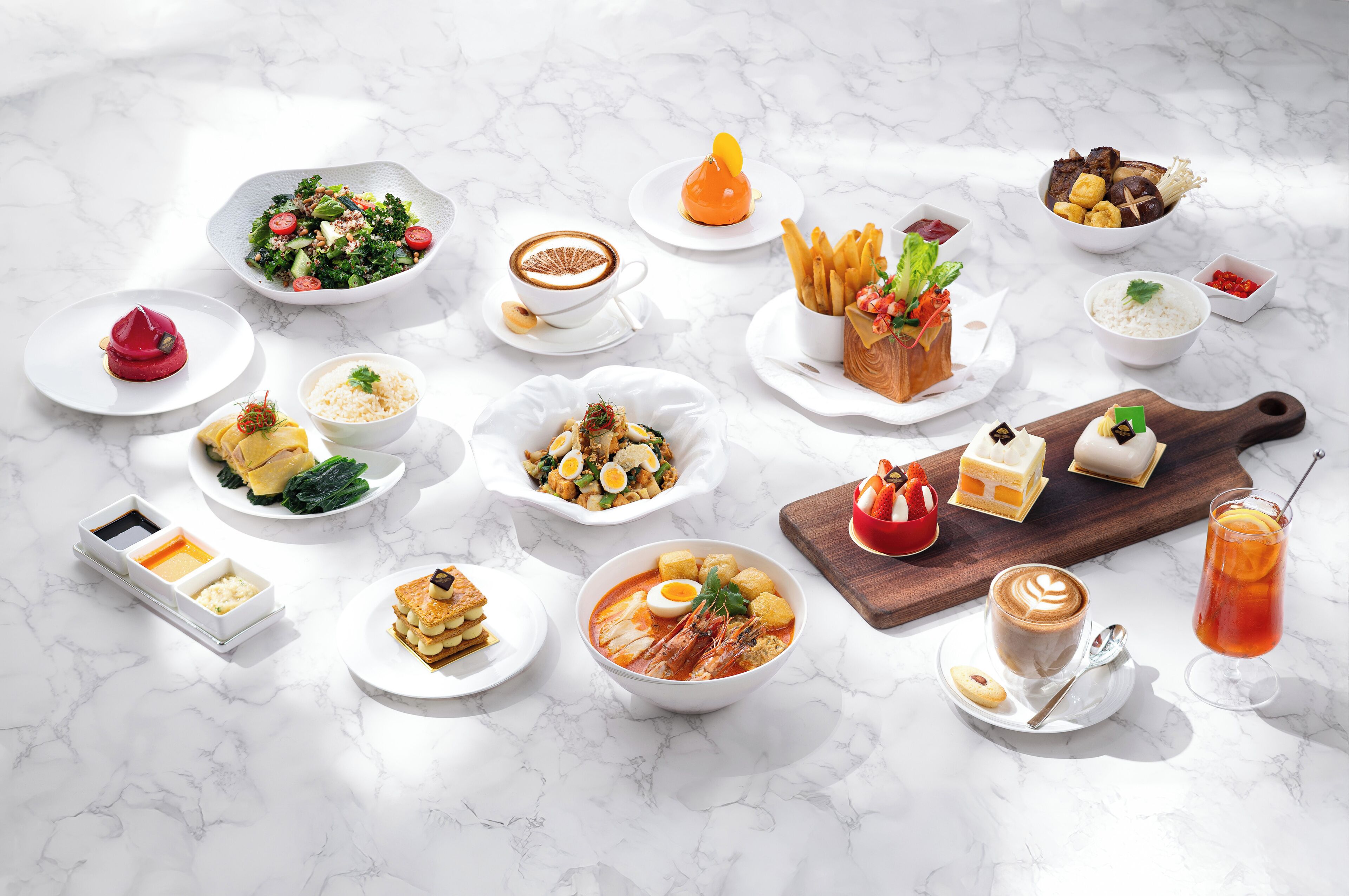 A variety of dishes and drinks arranged on a marble surface.