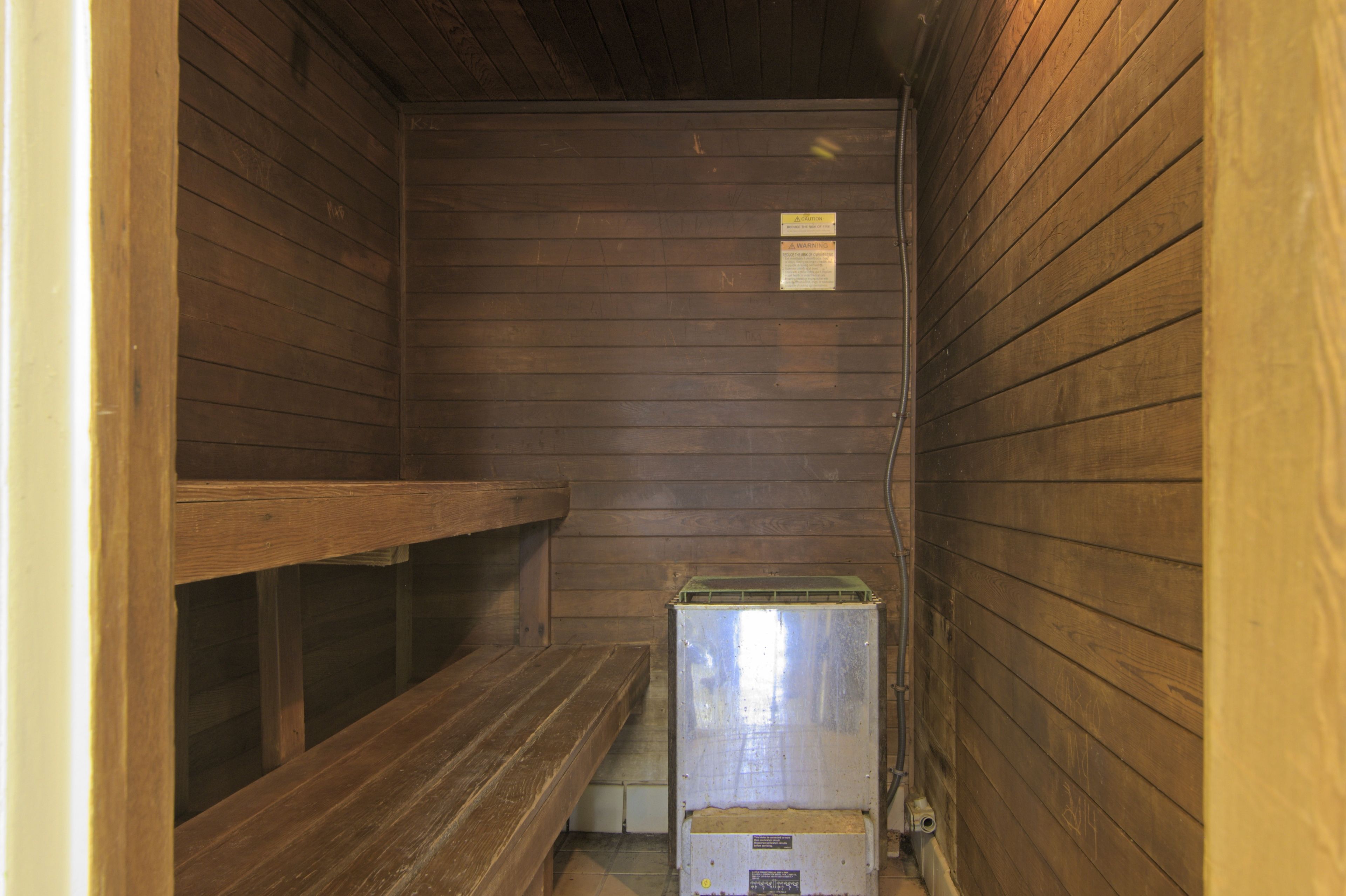Una habitación pequeña y estrecha con paredes de madera y un banco.