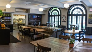 A spacious hotel lobby with a central seating area, a kitchenette, and large windows. - Chicago Getaway Hostel (Chicago)