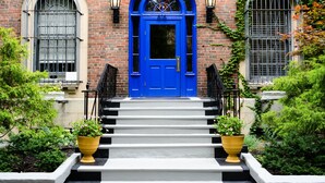 A building with a blue door, brick walls, and a set of stairs leading to the entrance. - Chicago Getaway Hostel (Chicago)