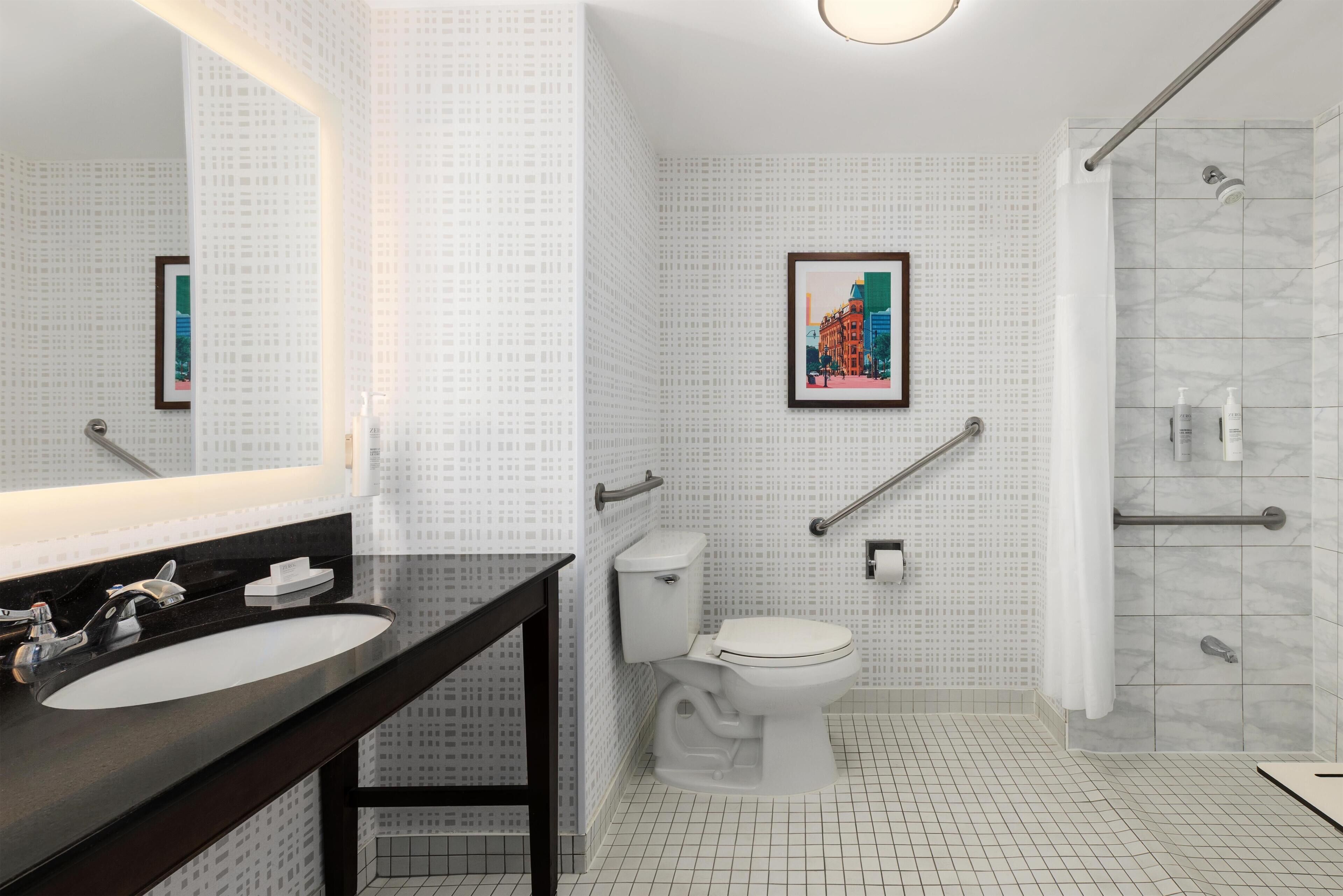 A modern bathroom with a large mirror, a sink, a toilet, and a shower area.