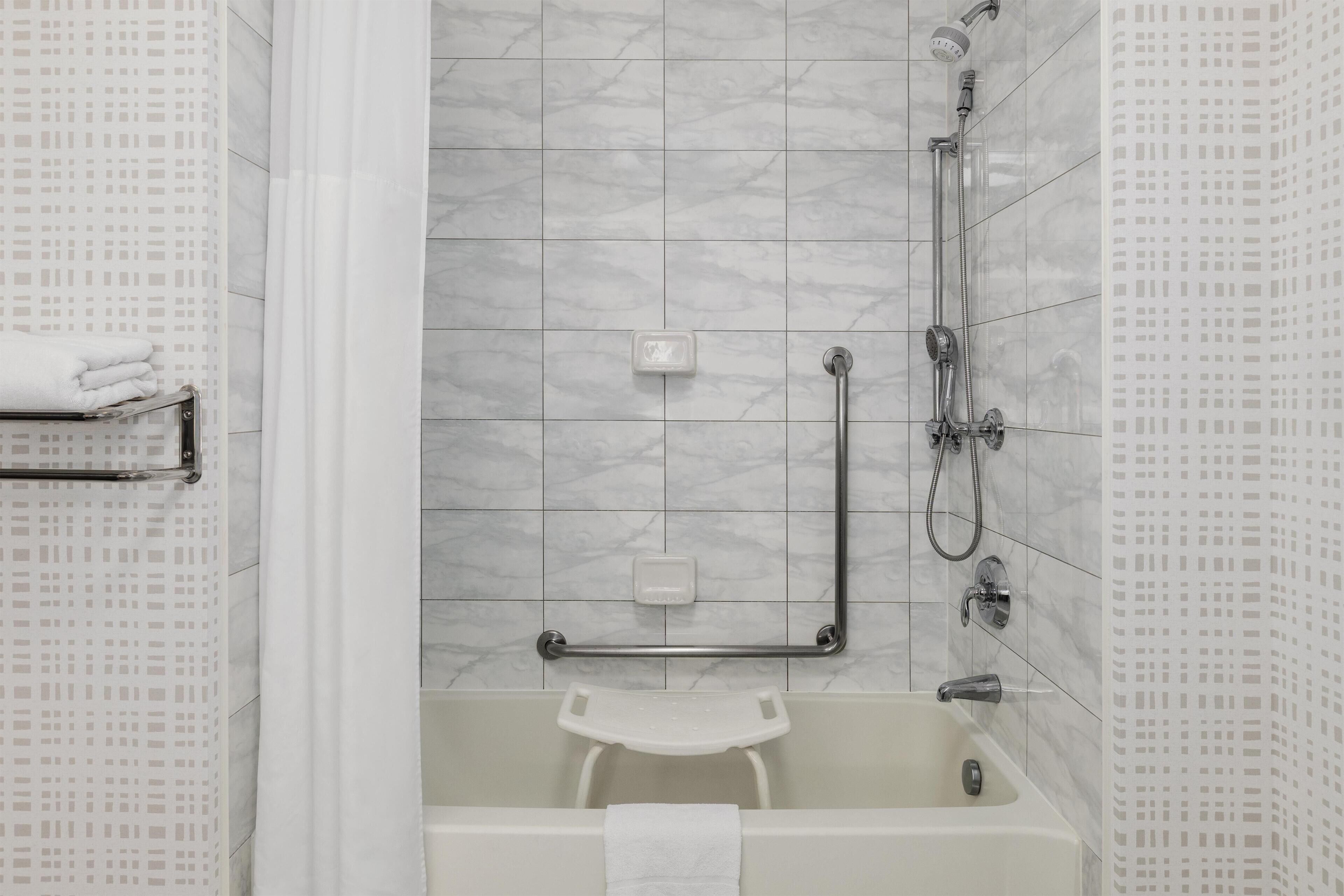 Un baño con ducha, bañera y retrete.