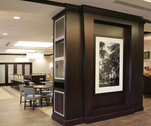 A hotel lobby with a reception desk, seating area, and a framed black and white photograph on the wall. - Hampton Inn by Hilton Toronto Airport Corporate Centre (Toronto)