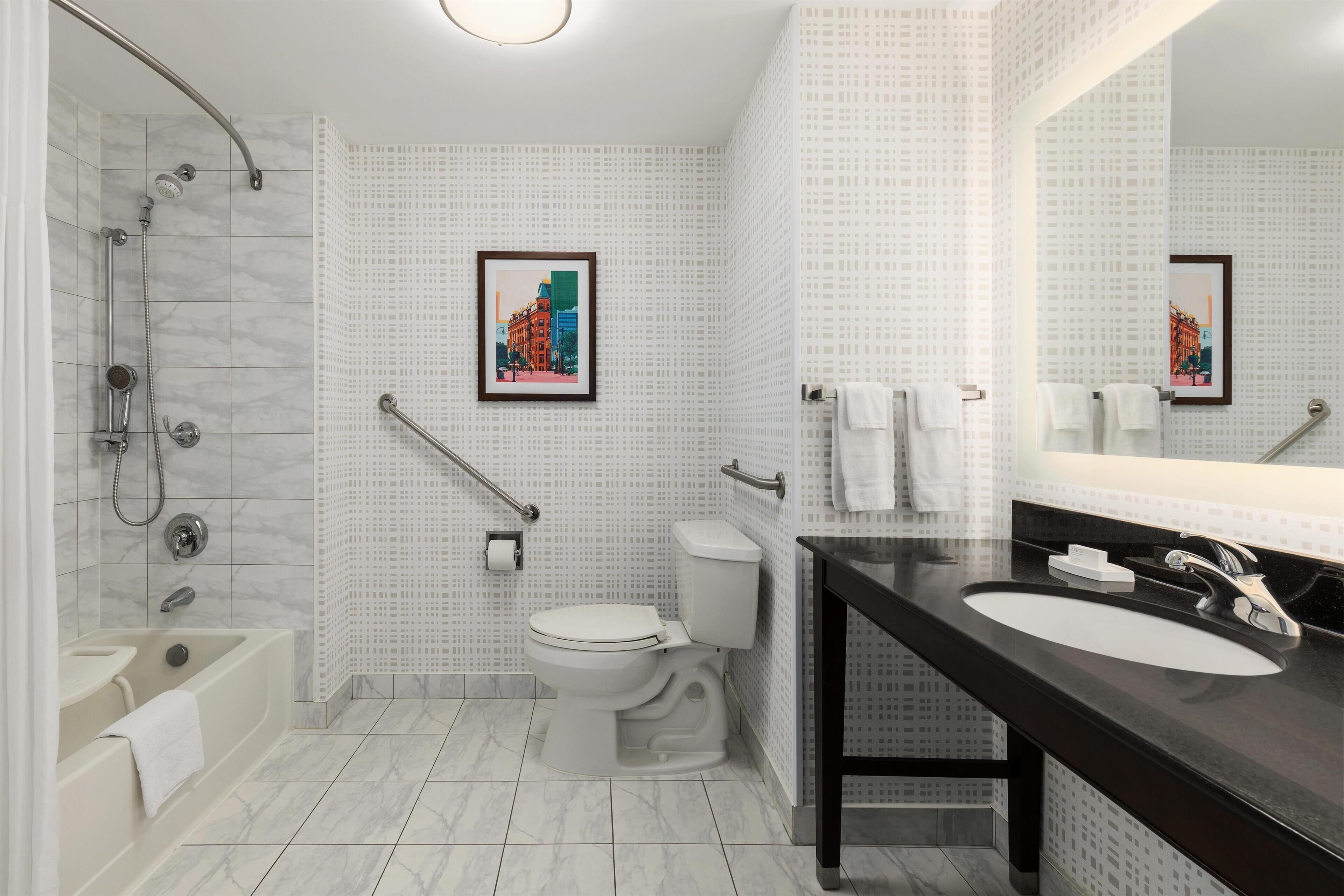 A modern bathroom with a shower, toilet, and sink.
