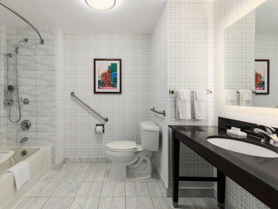 A modern bathroom with a shower, toilet, and sink.