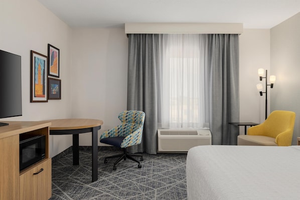 A hotel room with a bed, a desk, a chair, a television, and a window with curtains. - Hampton Inn by Hilton Toronto Airport Corporate Centre (Toronto)