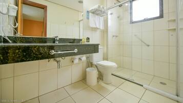 A bathroom with a shower, toilet, and sink.