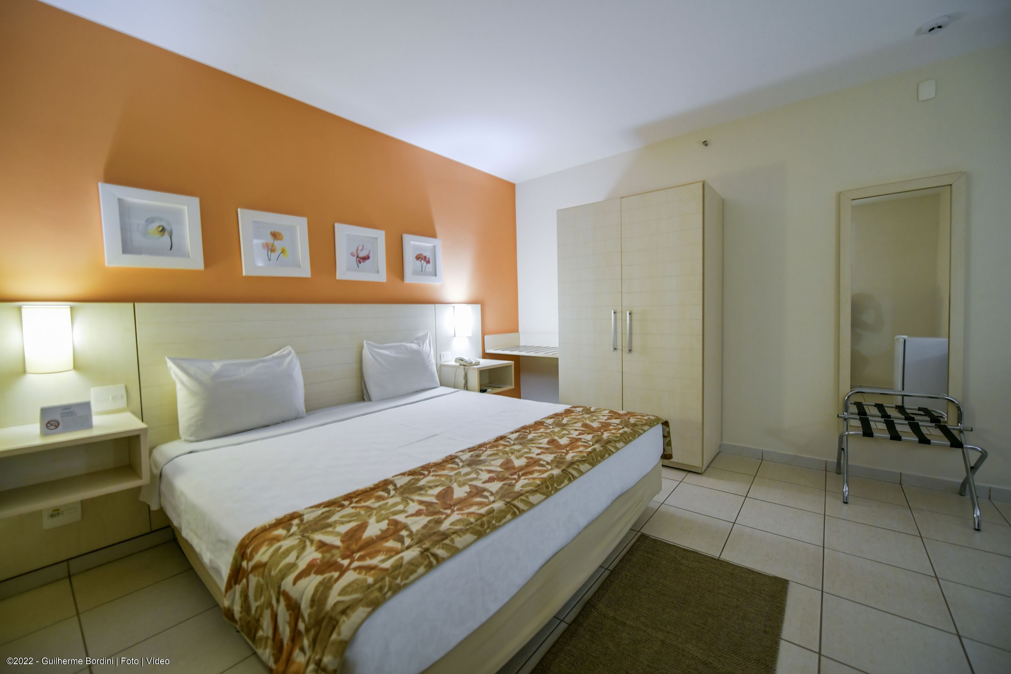 Ein Hotelzimmer mit Bett, Nachttischen, einem Kleiderschrank und einer kleinen Sitzecke.