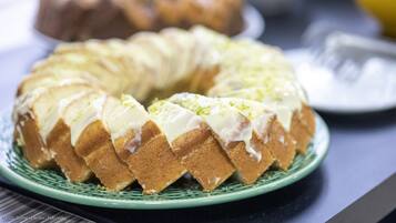 Um bolo bundt com cobertura branca sobre um prato verde.