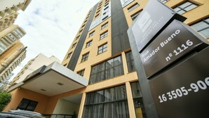 A multi-story building with a modern architectural design, featuring balconies and large windows.