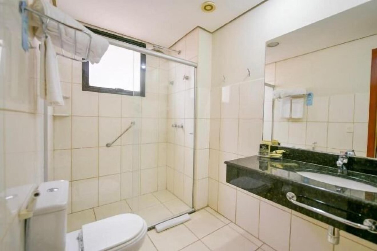 A bathroom with a shower, toilet, and sink.