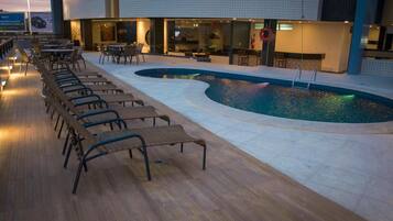 Zona de piscina amb gandules i una piscina.