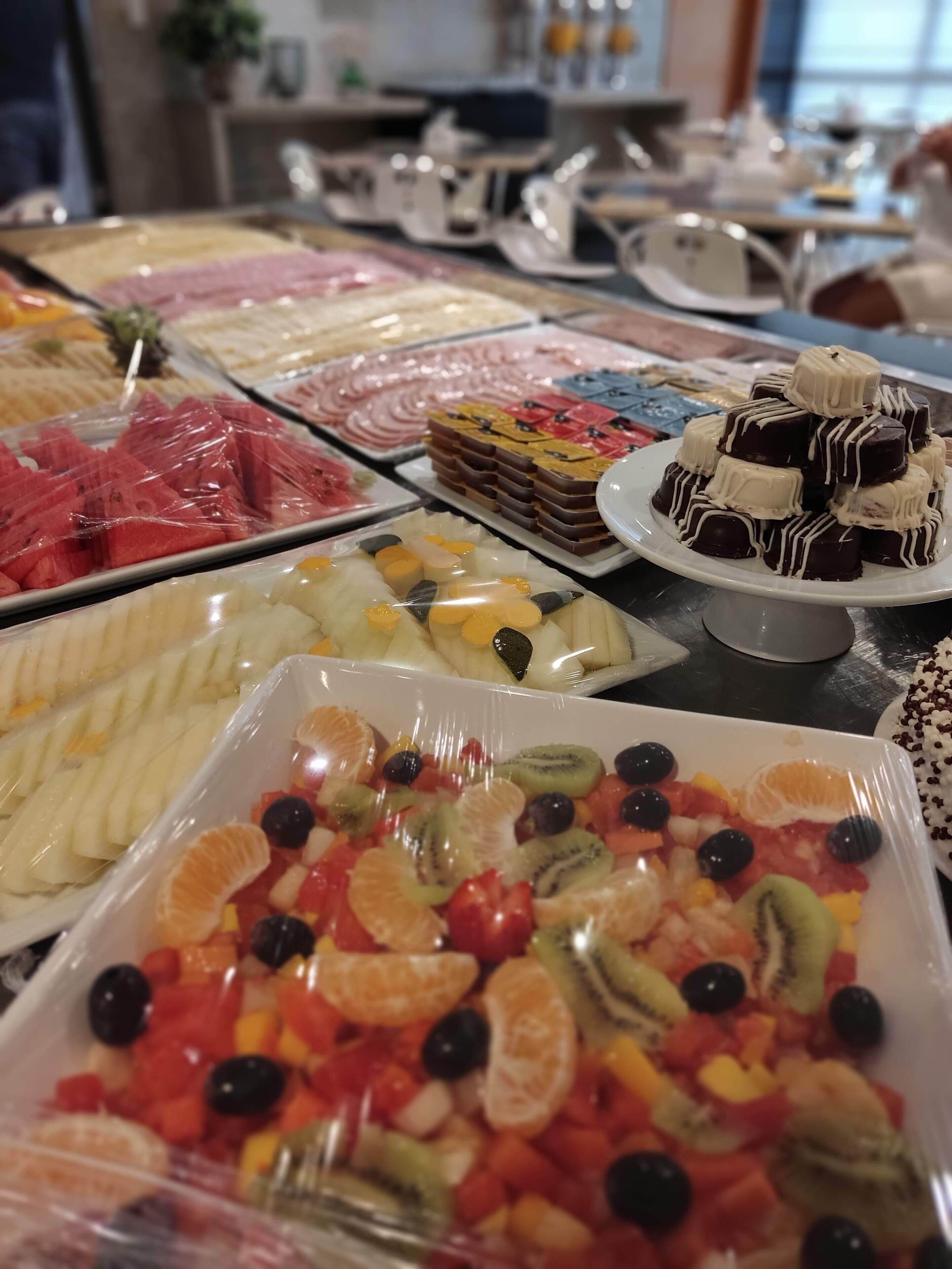 A buffet with various food items including fruits, desserts, and other dishes.