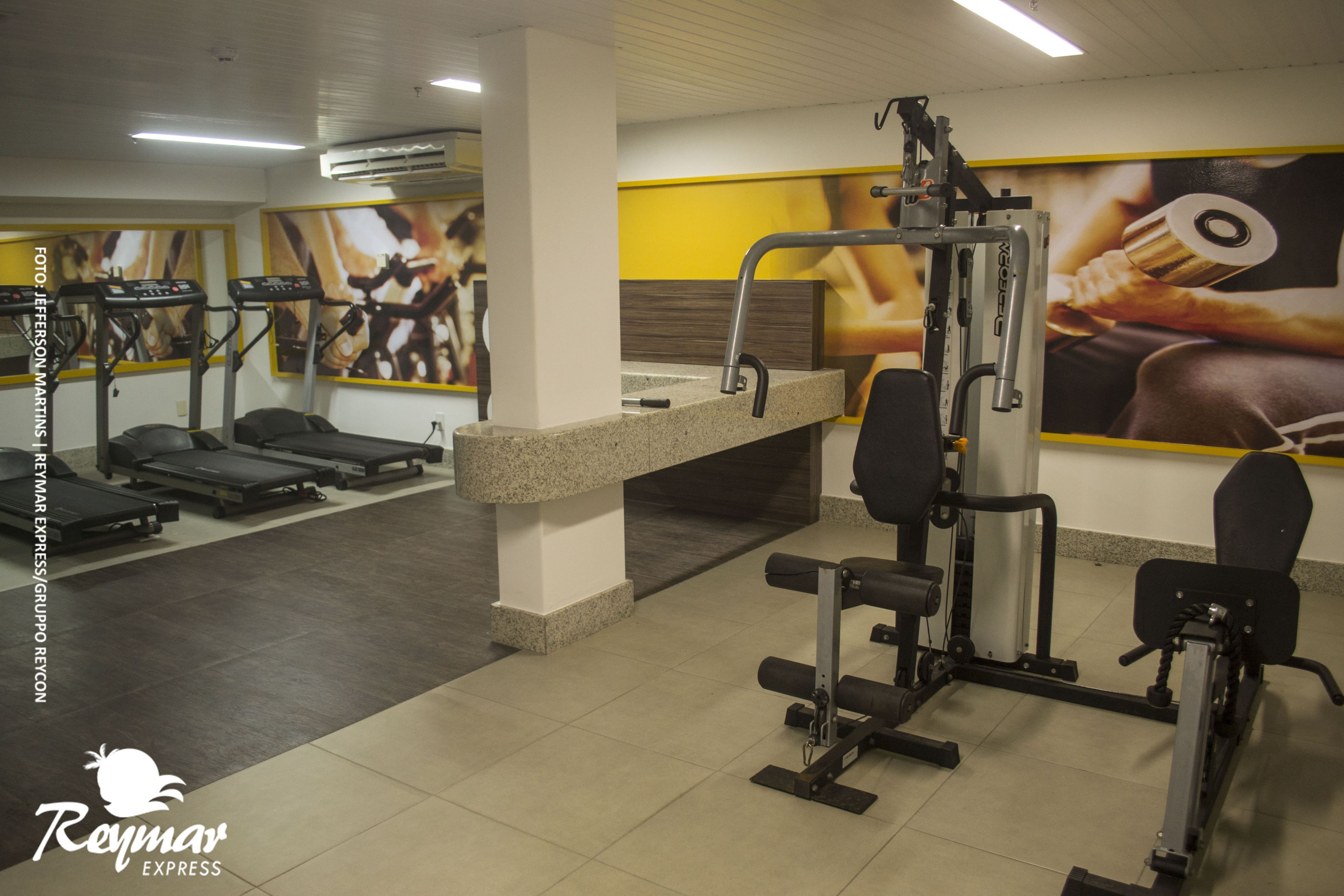A gym with treadmills, weight machines, and a counter.