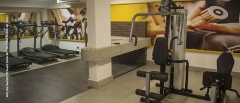 A gym with treadmills, weight machines, and a counter.