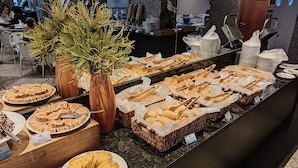 A buffet area with various baked goods, including cakes and pastries, displayed on a counter. - Reymar Hotel Maceió (Maceió)