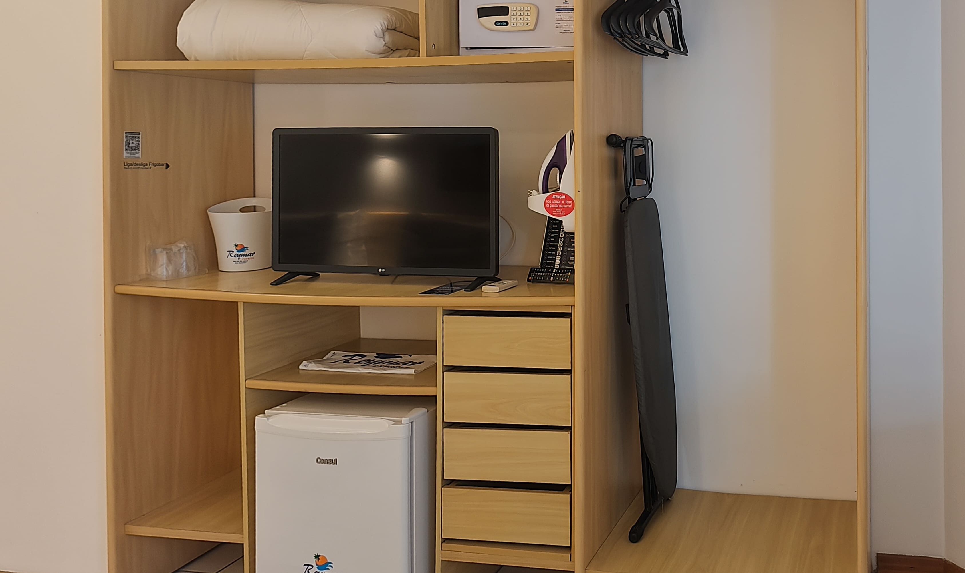 A wooden desk with a flat-screen TV, a small refrigerator, and a microwave.