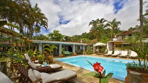 A poolside area with lounge chairs, a rose, and a book titled "Roberta".