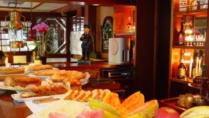 A buffet with various food items including bread, fruits, and a selection of beverages.