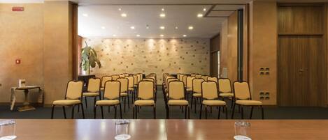 Ett konferensrum med ett långt bord, stolar och en projektor.