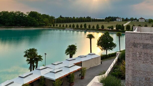 Un hôtel situé au bord de l’eau, doté d’une terrasse et offrant une vue sur le lac.