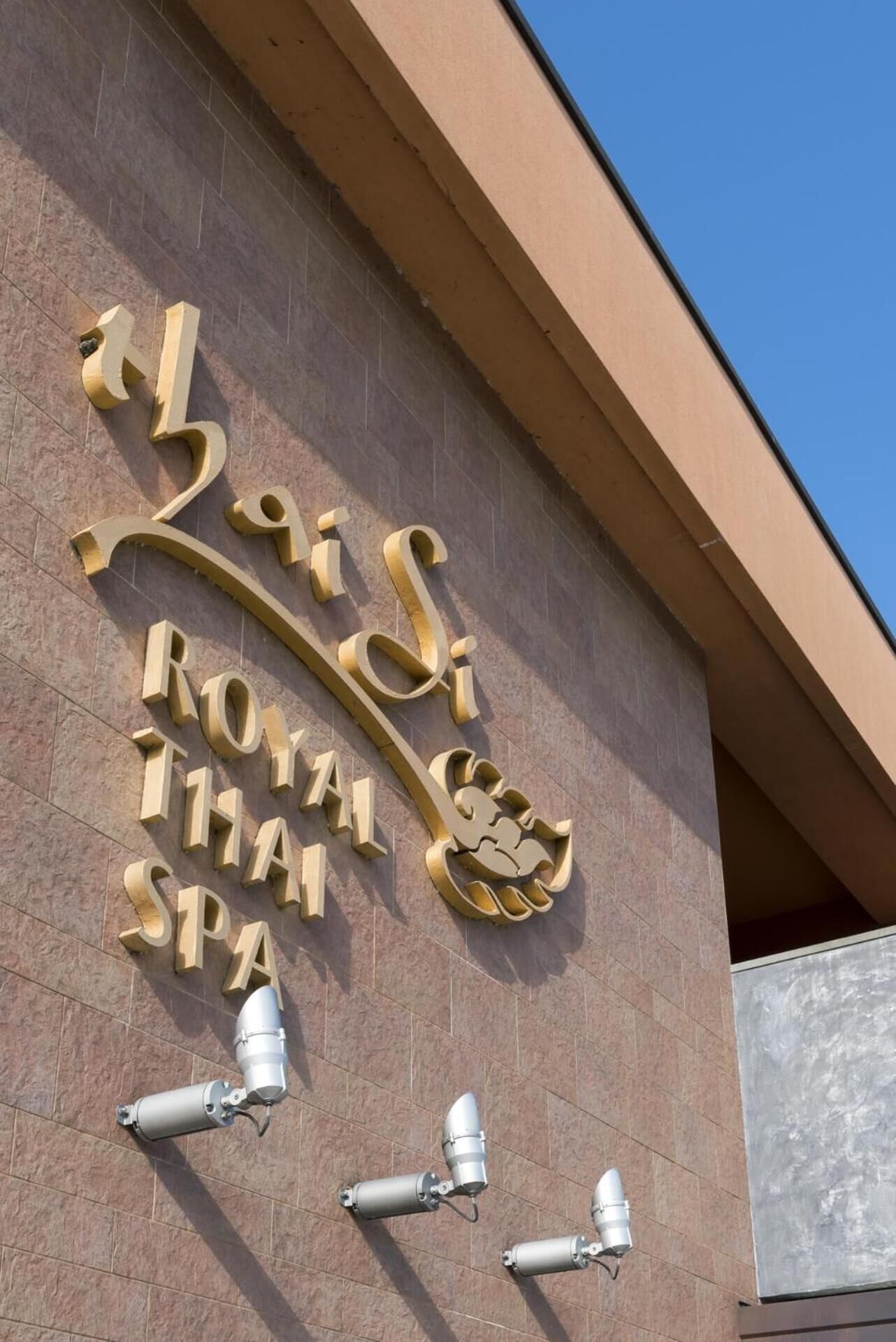 Une façade d’immeuble ornée d’une grande enseigne indiquant « Royal Thai Spa ».