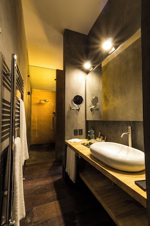 Une salle de bain moderne avec un grand miroir, un lavabo et un porte-serviettes.