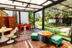 Un intérieur moderne avec un plancher en bois, un mur en verre et une vue sur un jardin.