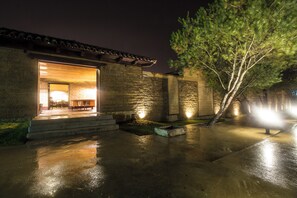 Un bâtiment avec une entrée ouverte, un patio et un arbre.