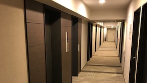 A long, narrow hallway with dark wooden doors and a carpeted floor. - Best Western Hotel Fino Osaka Shinsaibashi (Osaka)