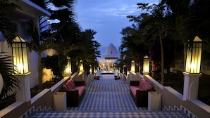 A hotel lobby with a checkered floor, seating areas, and a view of the ocean. - Coco Ocean Resort & Spa (Serrekunda)