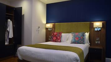 A hotel room with a bed, bedside tables, a wardrobe, and a nightstand.