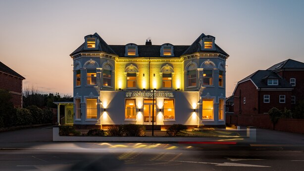 Un edificio grande e histórico con una entrada destacada y varias ventanas, identificado como Hotel St. Andrews.