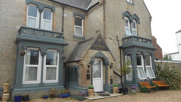 A two-story building with a traditional architectural style, featuring a prominent sign for 'The George Red & Breakfast'. - The George B&B (Weymouth)