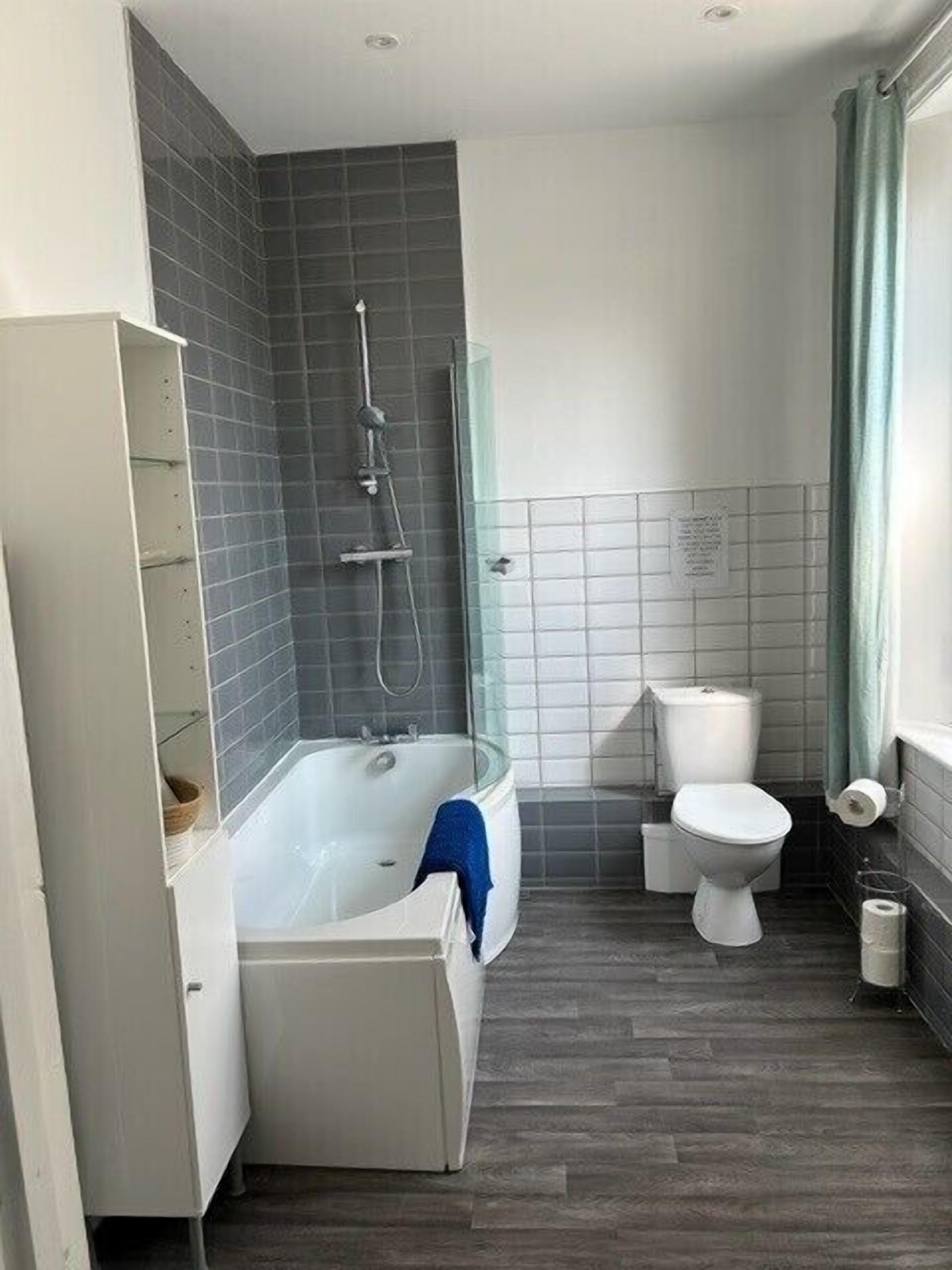 Un baño con bañera, inodoro y ducha.