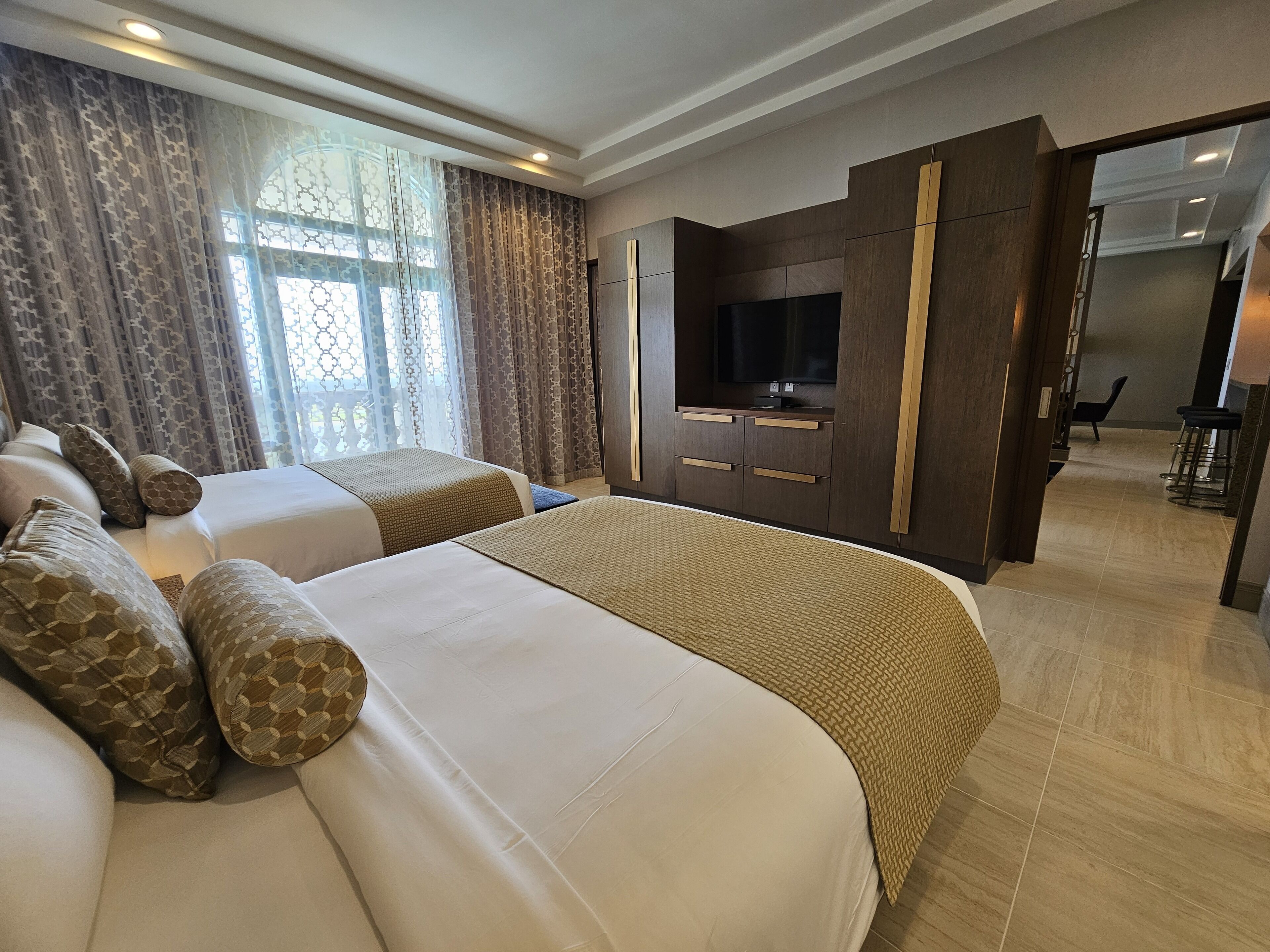 Una habitación de hotel con dos camas, televisión y minibar.