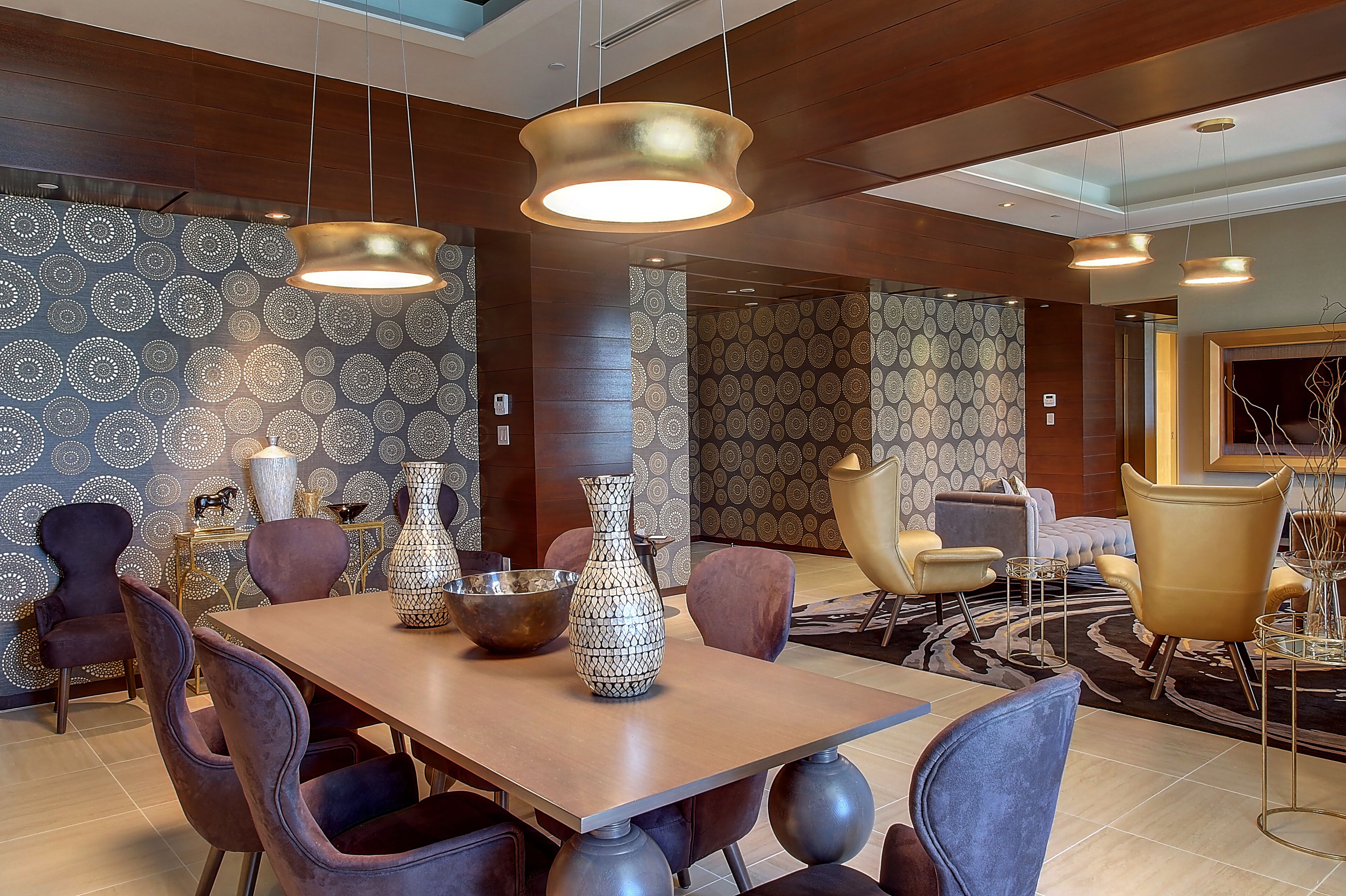 A modern dining area with a wooden table, multiple chairs, and decorative vases.