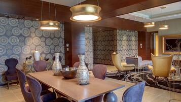 A modern dining area with a wooden table, multiple chairs, and decorative vases.