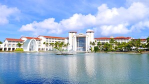 A large hotel with a central building featuring a large arched entrance and a fountain in front. - Leopalace Resort Guam (Yona)