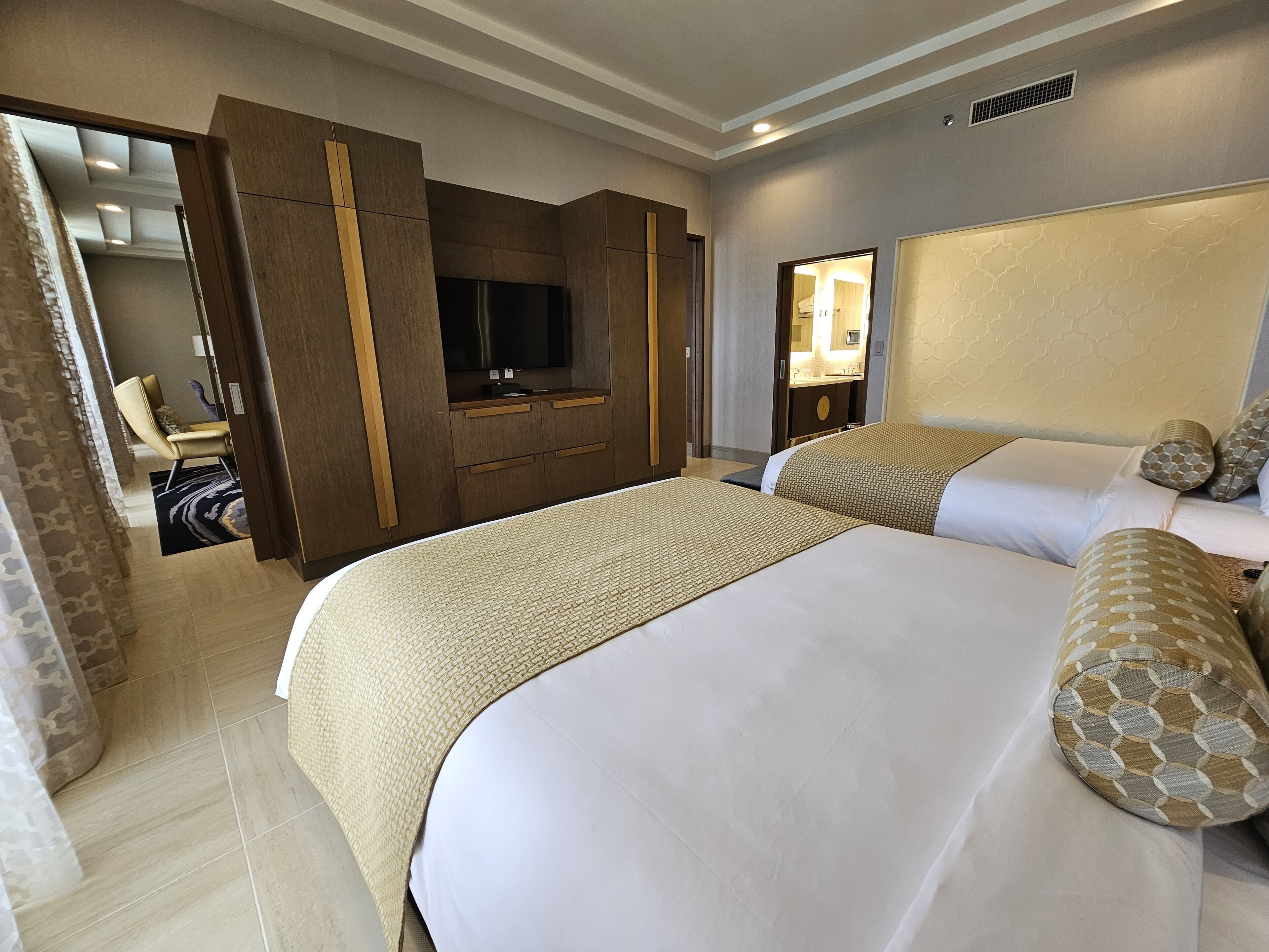 A hotel room with a large bed, a TV, a desk, and a bathroom.