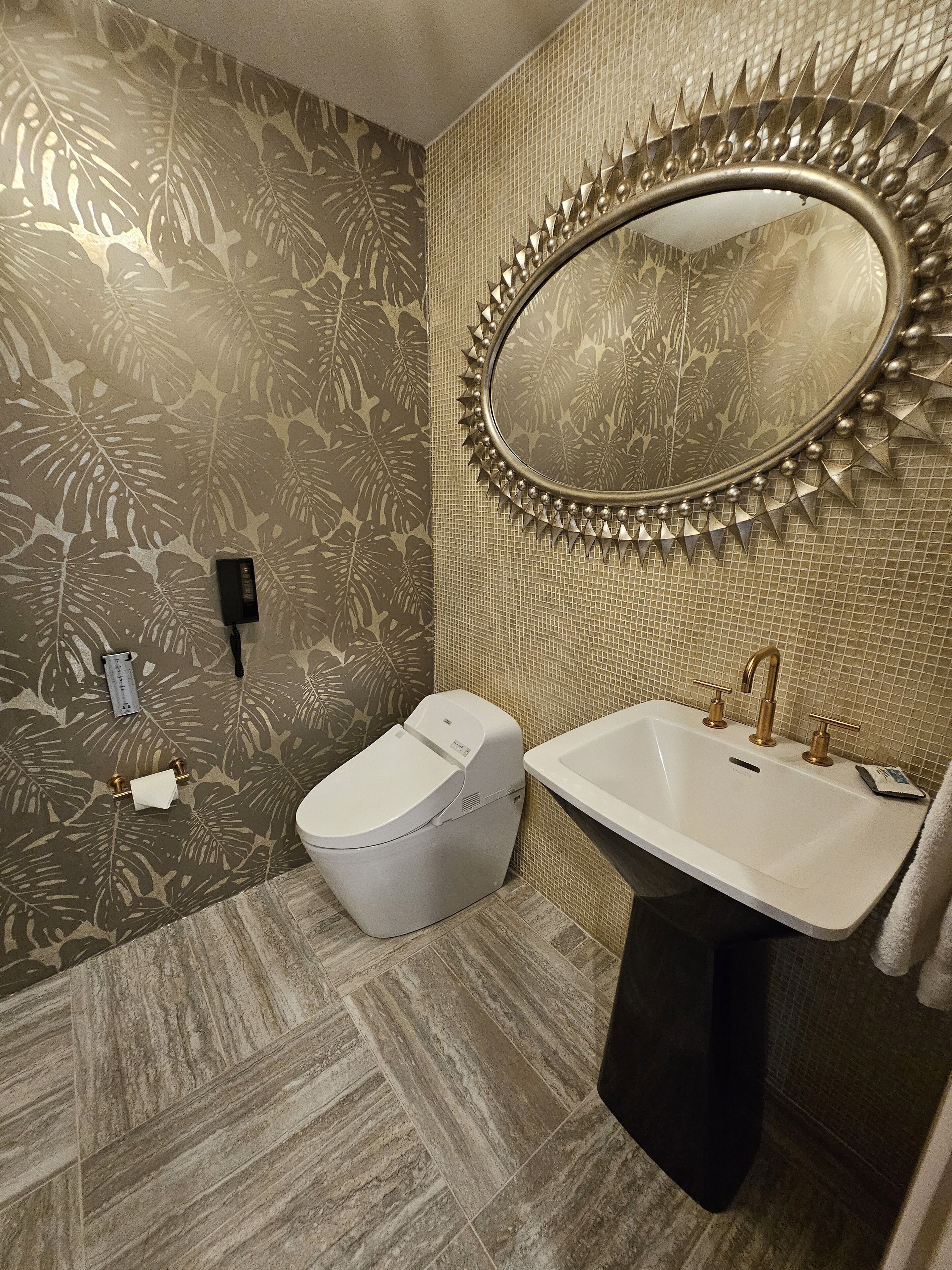 A bathroom with a toilet, sink, and mirror.